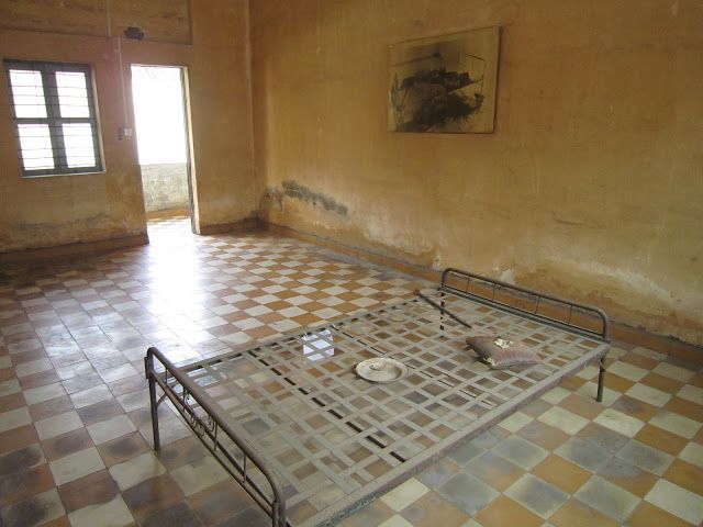 Una de las habitaciones de tortura del S-21 con foto en la pared de un hombre muerto por tortura