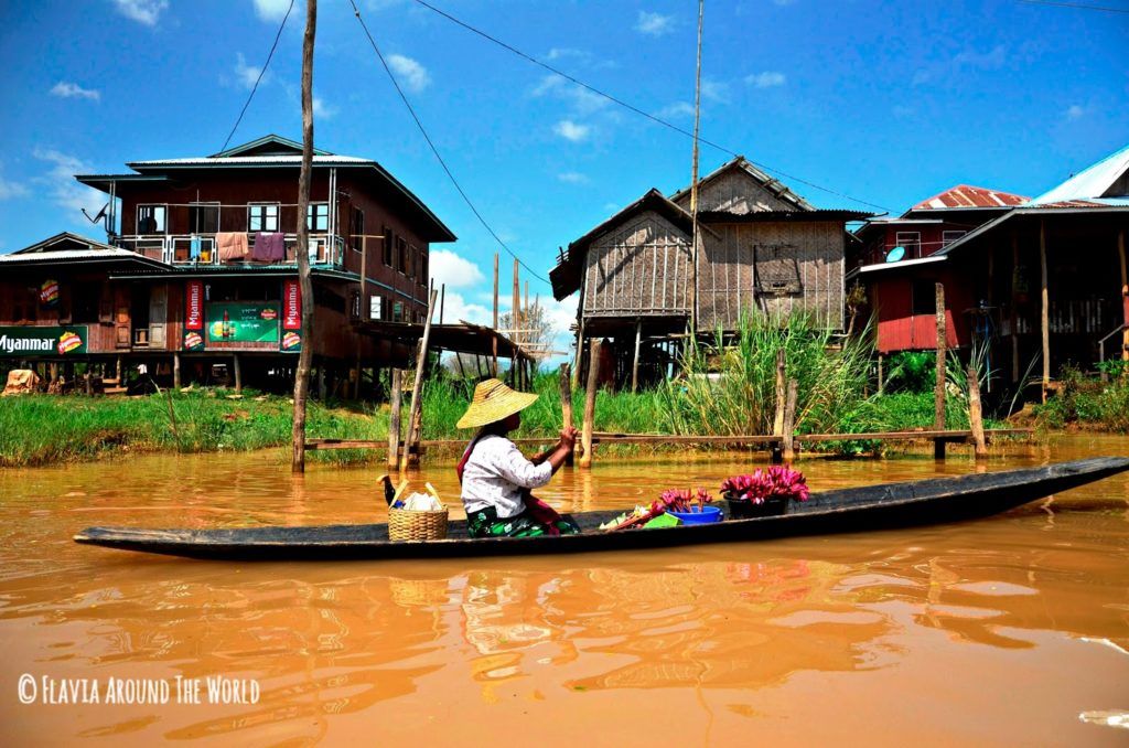 Mujer en barca vendiendo flores por el lago Inle