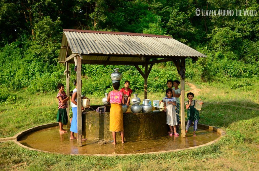 Mujeres y niñas cogiendo agua del pozo en Mrauk U